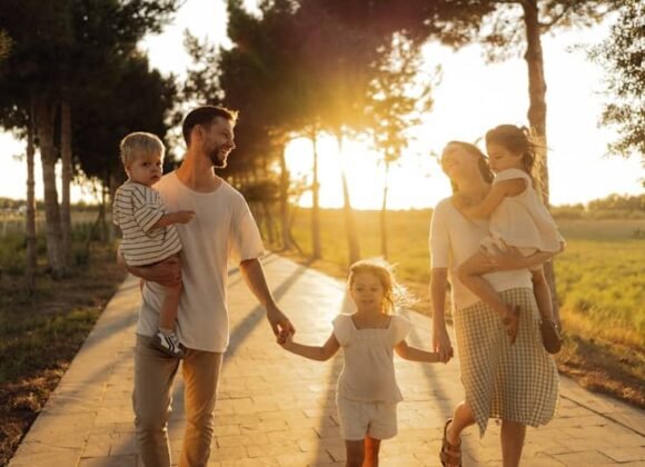 Family walking on path with trees at sunset